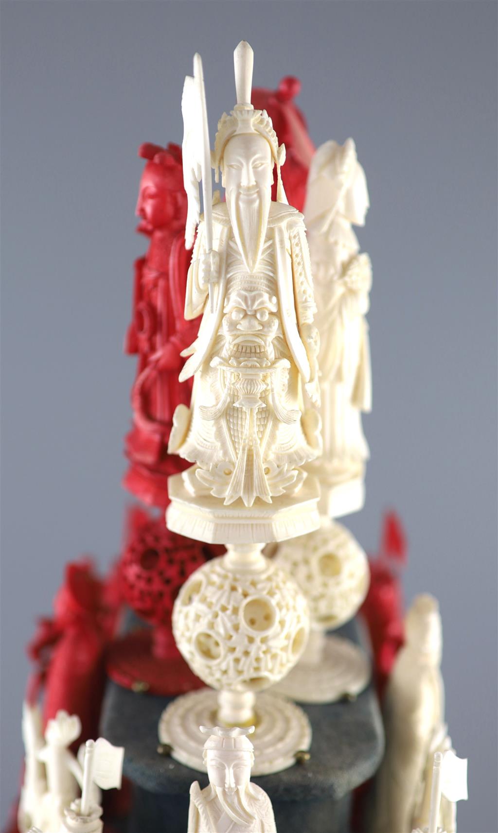 A set of 19th century Cantonese carved and red stained ivory chess pieces under dome, white king 20cm high